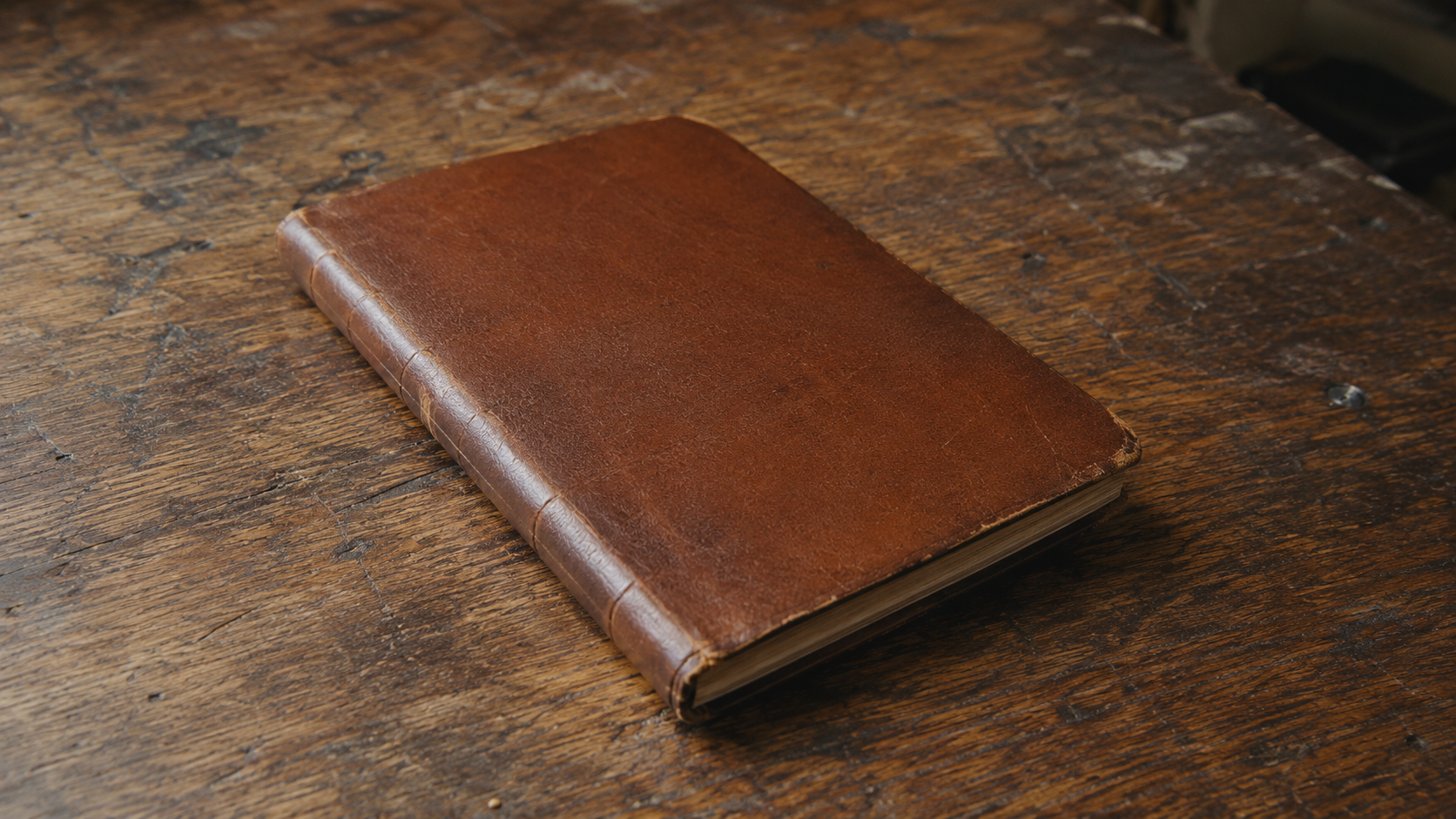 Photo-Realism Calibration: A Blank Leather Notebook on a Rustic Wooden Desk